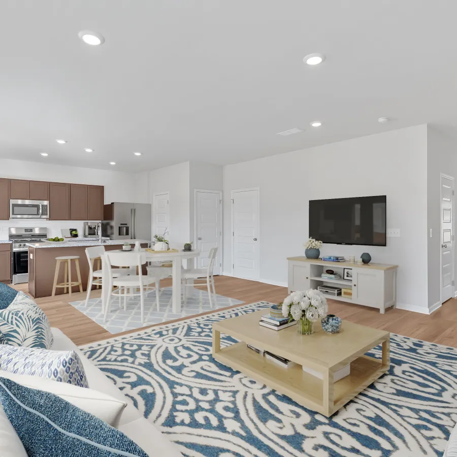 Modern living room featuring stylish furniture, light colors, and open layout with kitchen view.