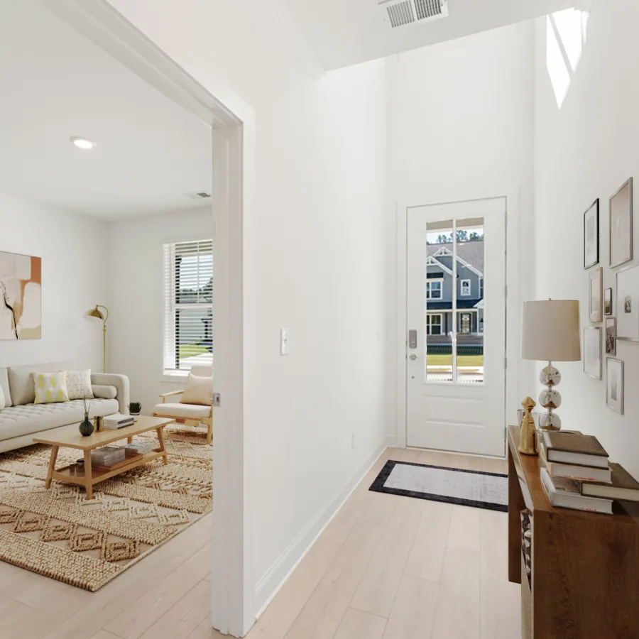 Bright modern entryway with wooden console and gallery wall leading to a living room with sofa and coffee table.