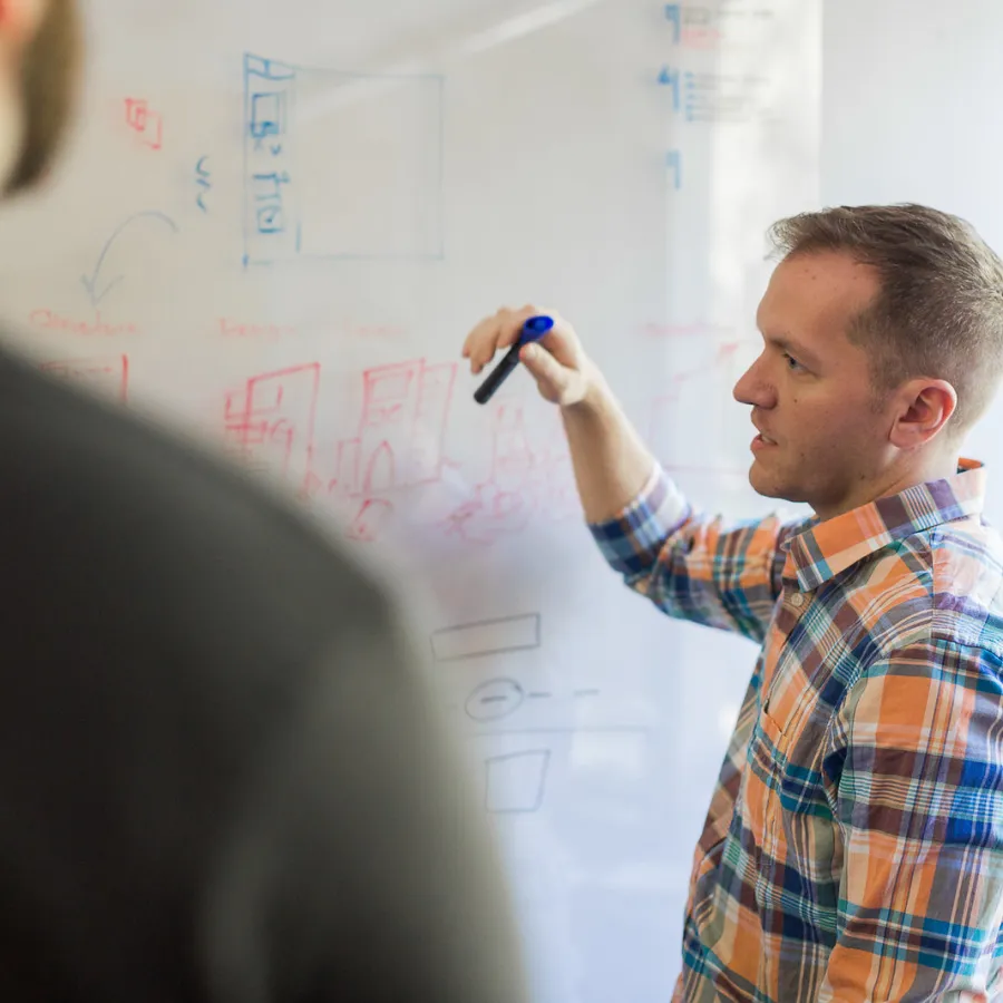 a man writing on a whiteboard