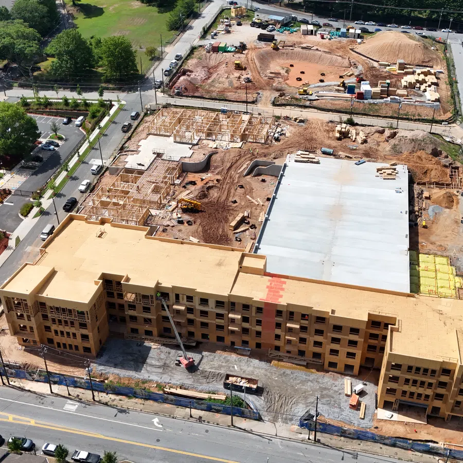 A large multi-story building under construction with ongoing site work and equipment in an urban area.