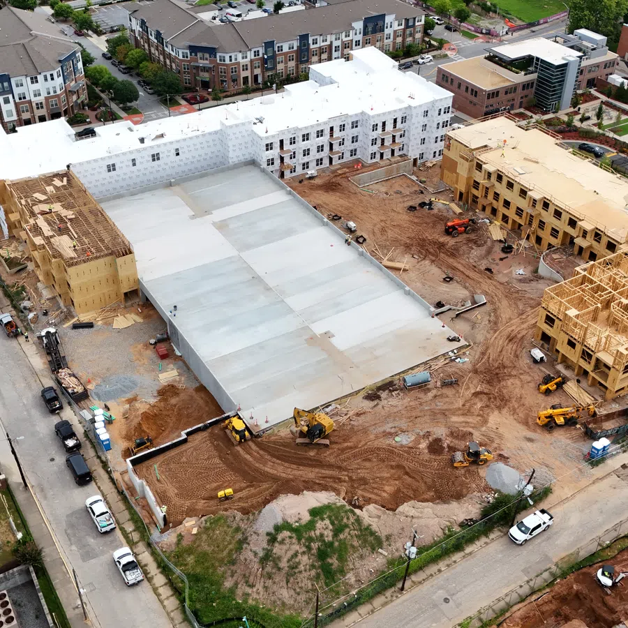 Aerial view of a large residential complex under construction showing multiple buildings at various stages of development.