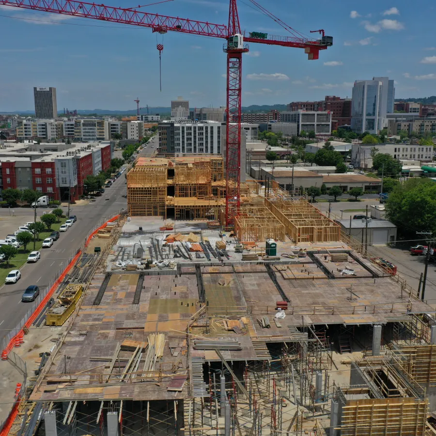 a construction site with cranes and cars