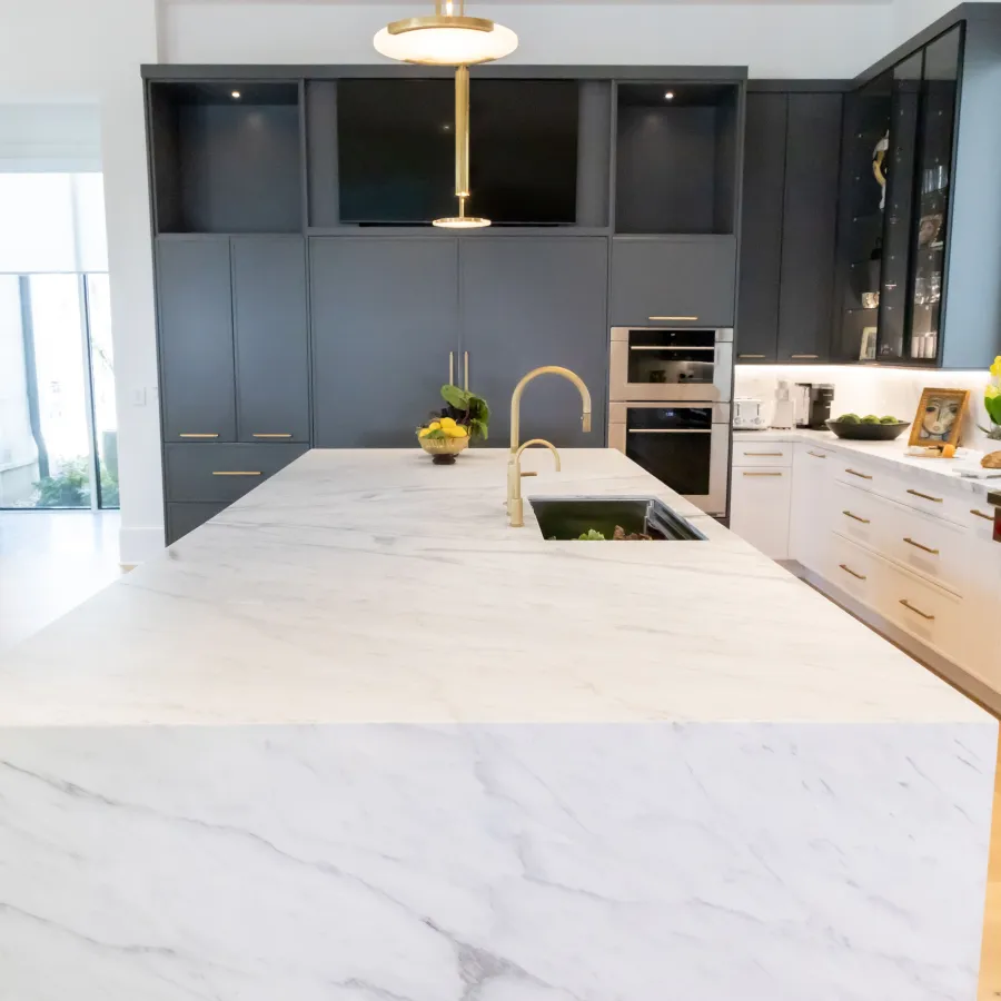 Modern kitchen with a marble island, dark cabinetry, and sleek appliances for a stylish look.