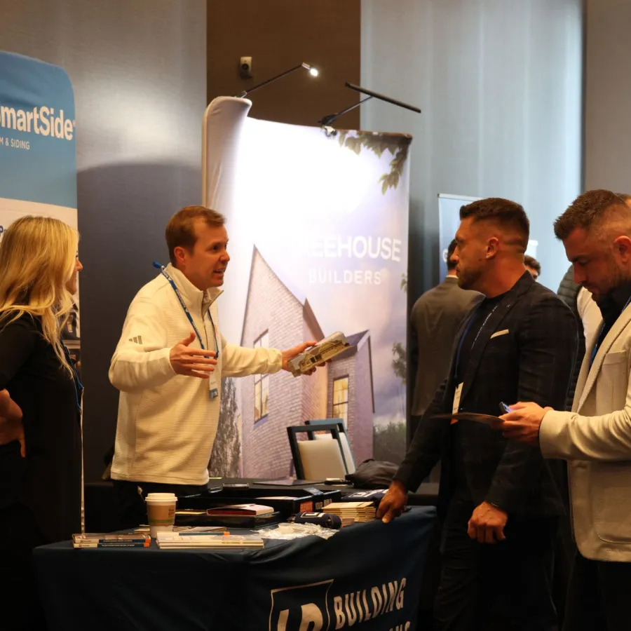 Business professionals discussing building materials at a trade show booth with promotional displays