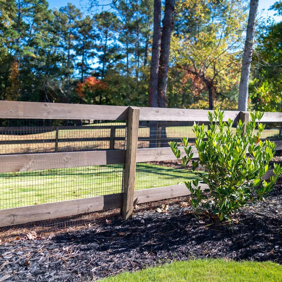 a fenced in area with trees in the background