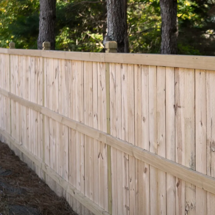 a wooden fence with trees in the background