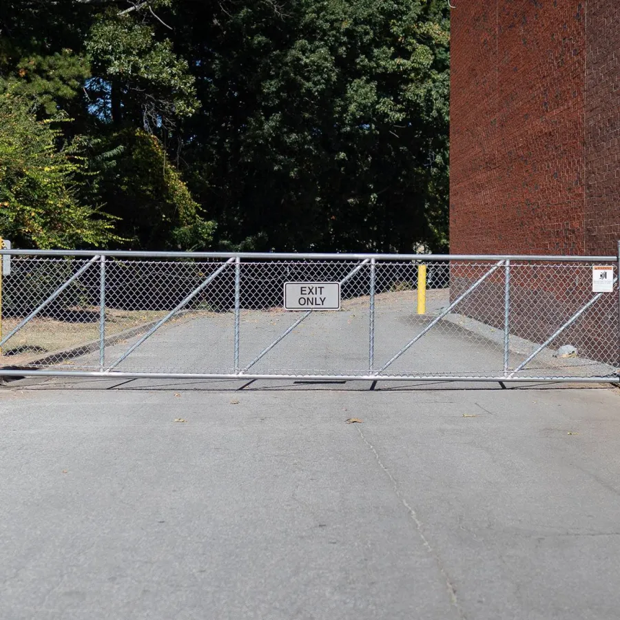 a fenced off area with a metal gate and a brick building