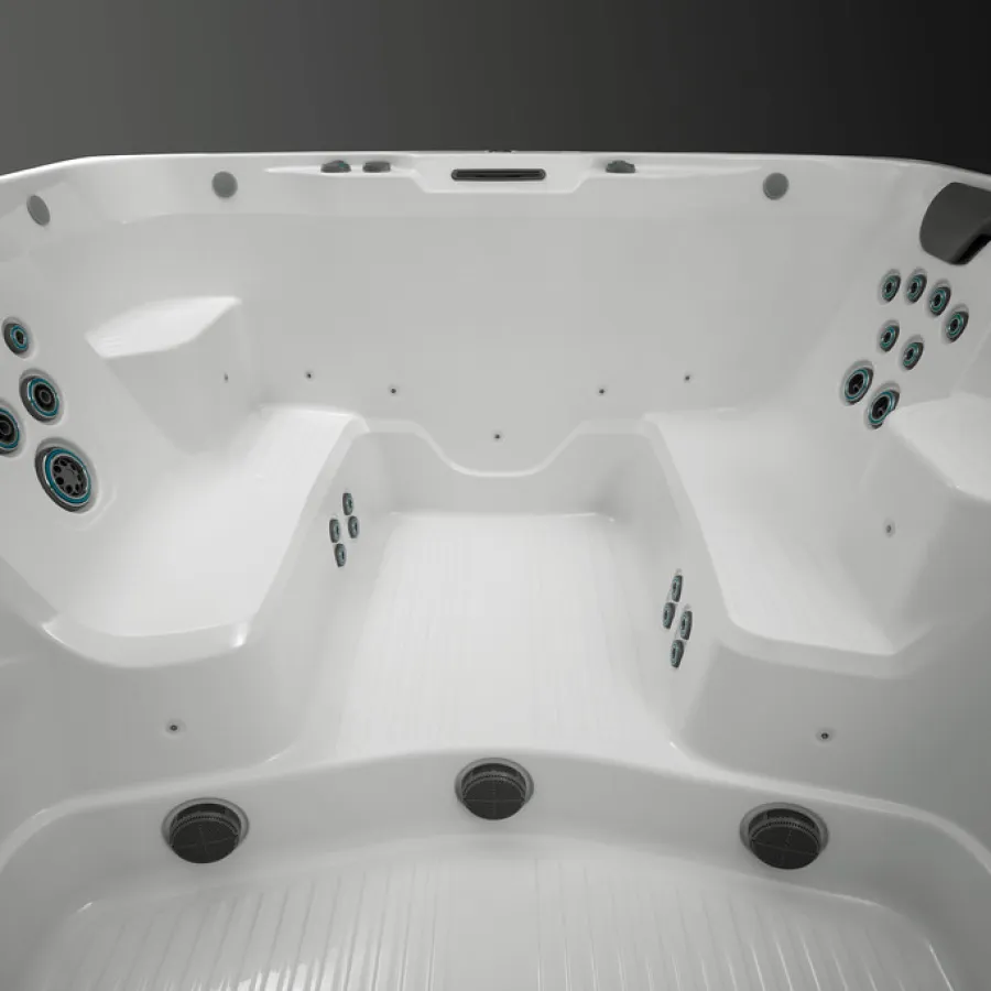 Interior view of a white empty hot tub with multiple jets and two black headrests on a gray background