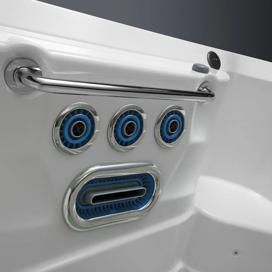 Close-up of a white spa tub with four blue and chrome water jets and a chrome safety handlebar.