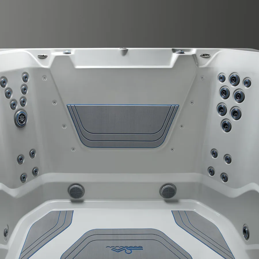 White modern hot tub interior with multiple water jets and textured gray seating pads for comfort.