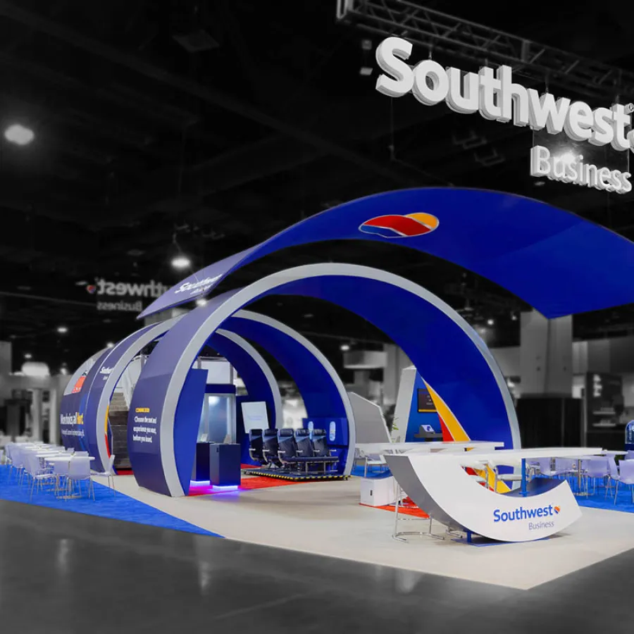 Modern Southwest Business exhibition booth with blue arches, seating, and branded signage at trade show.