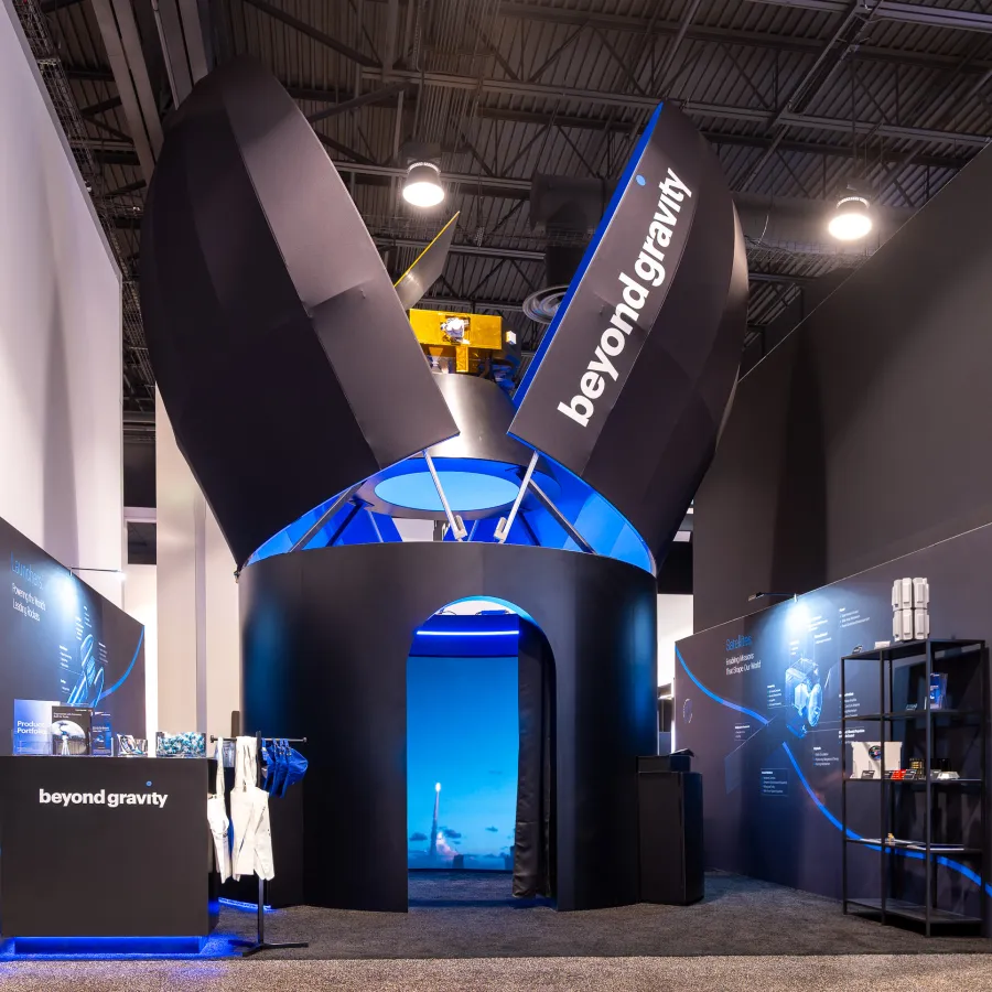 Modern Beyond Gravity exhibit booth with black and blue design elements at a trade show.