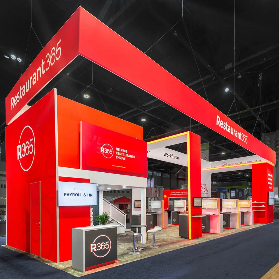 Bright red Restaurant365 trade show booth featuring digital displays, seating, and branding in an exhibition hall.