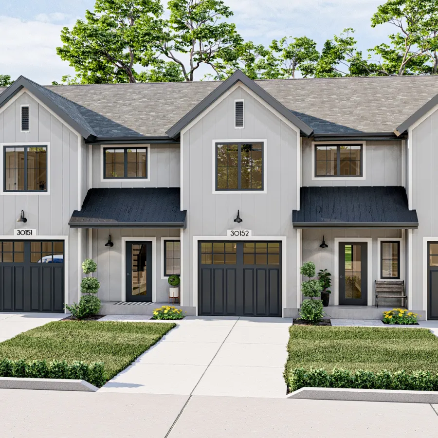 Modern three-unit townhouse with white siding, black garage doors, and landscaped yards under blue sky.