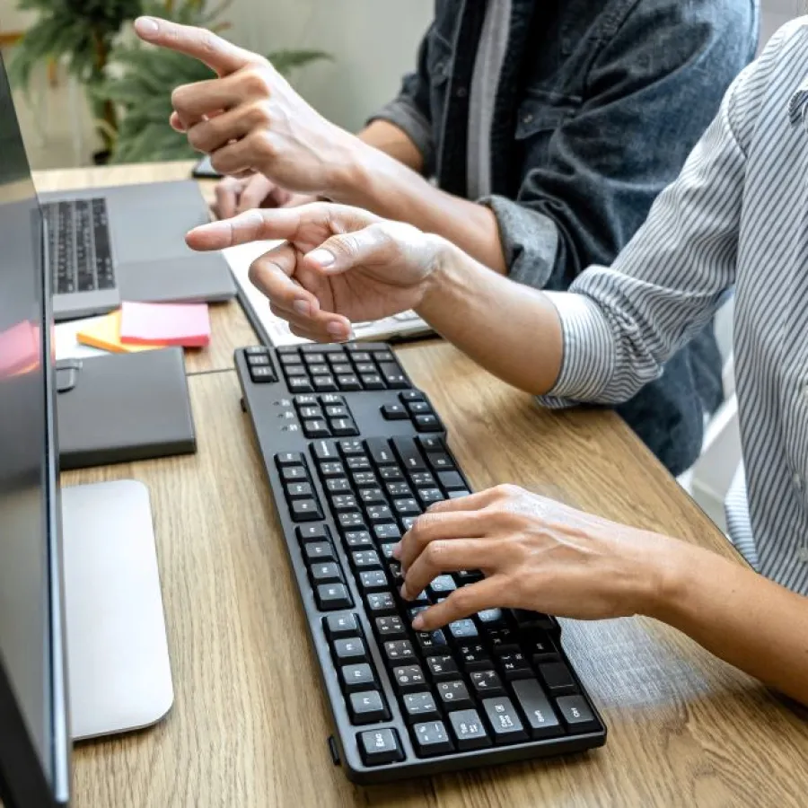 a man and a woman working on a computer