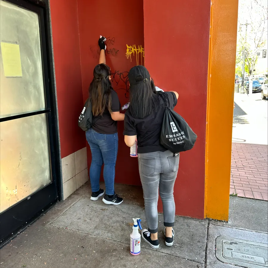 a couple of women standing in front of a red building