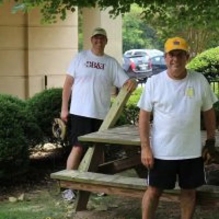 two men standing next to a wood structure
