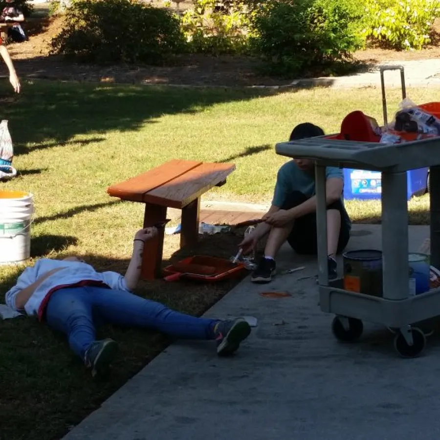 a person lying on the ground next to a picnic table