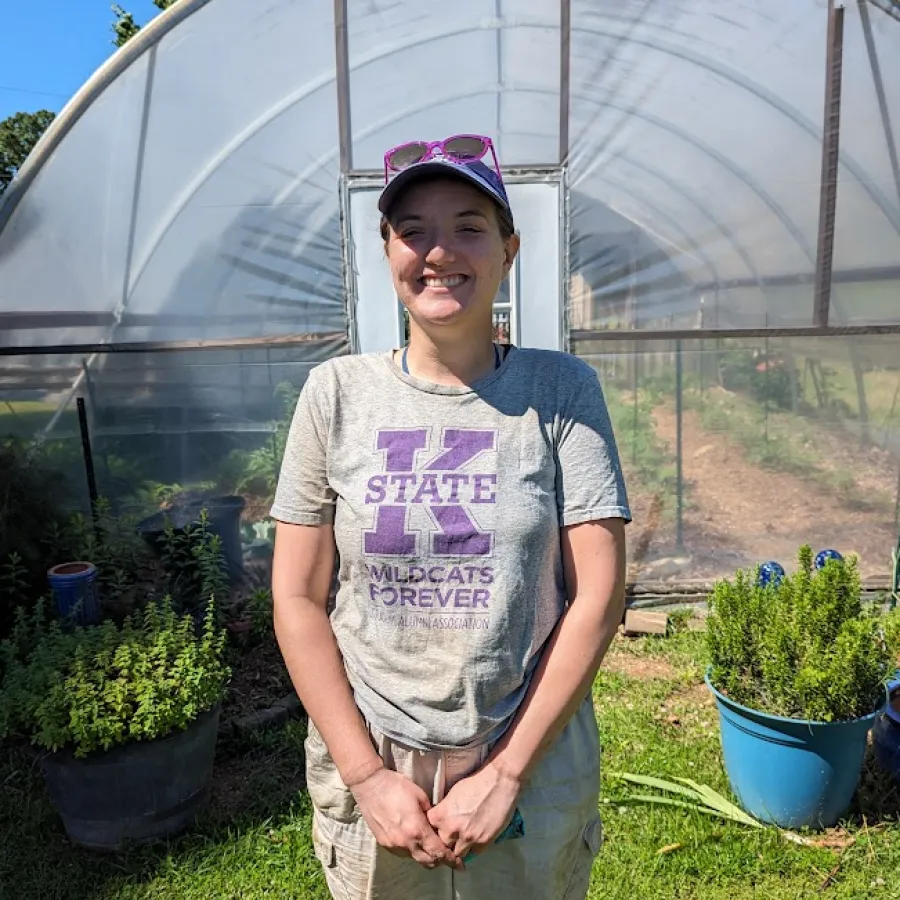 a person standing in front of a greenhouse