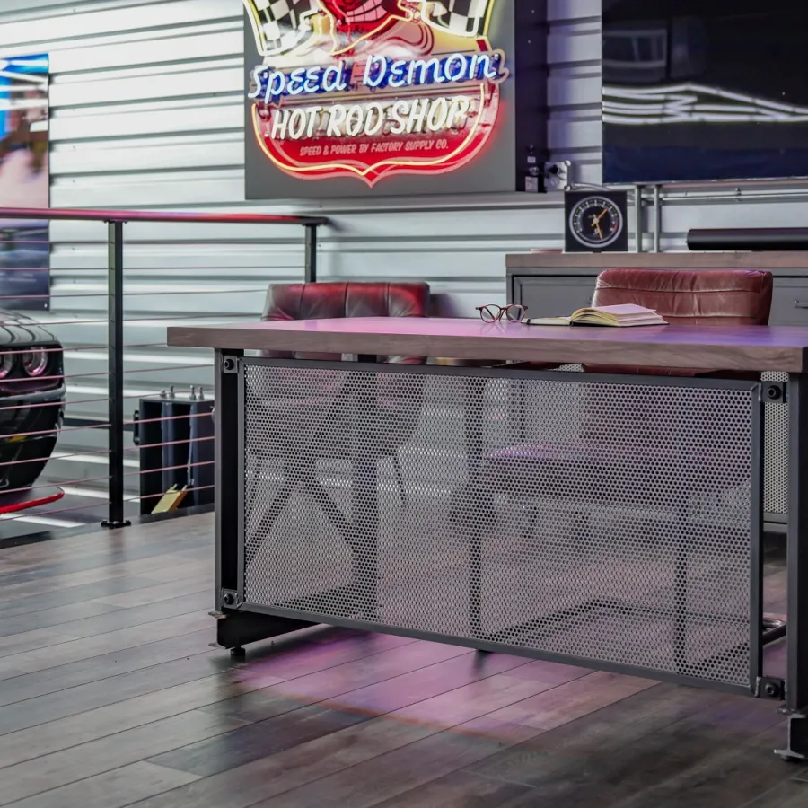 Modern industrial office space with metal desk, leather chairs, neon signs, and a black muscle car in background.