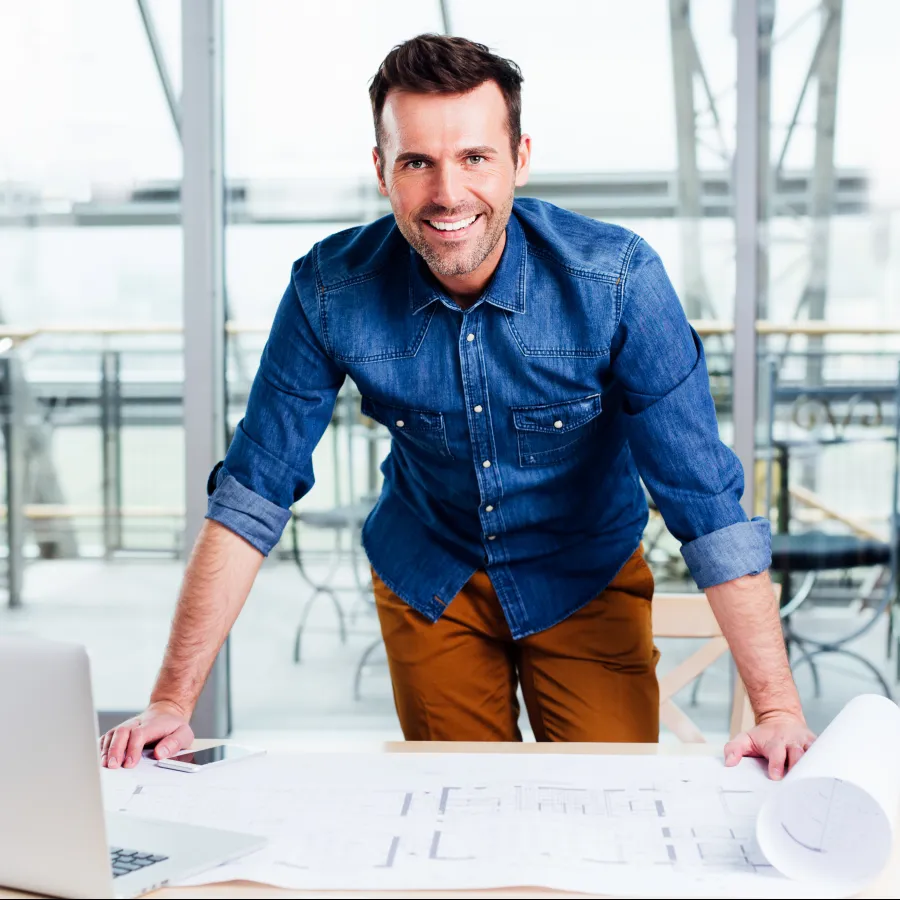 a man standing next to a laptop