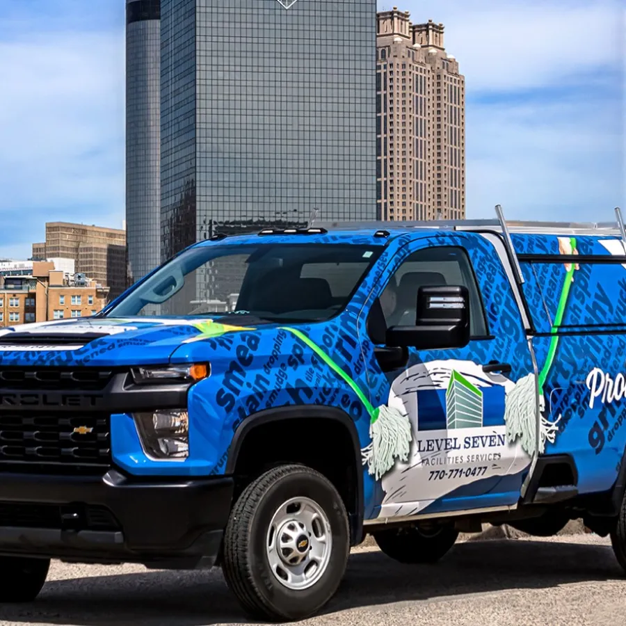 Blue Level Seven service truck parked in front of Atlanta city skyline on a sunny day.