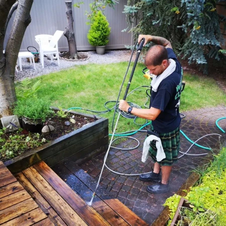 a person using a hose to water a garden