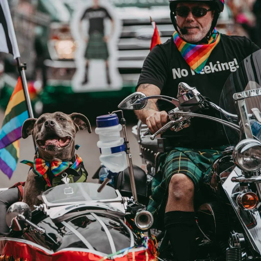 a man on a motorcycle with a dog in a motorcycle