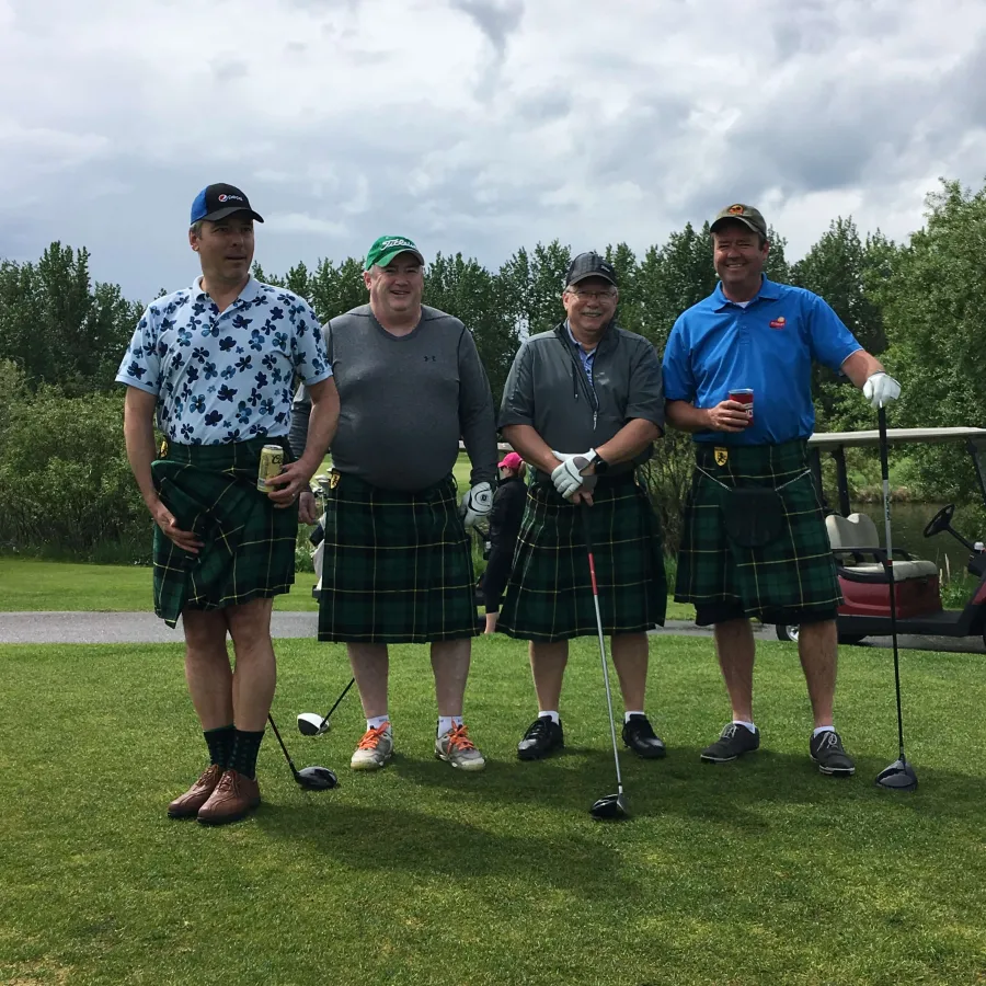 a group of men posing for a picture on a golf course