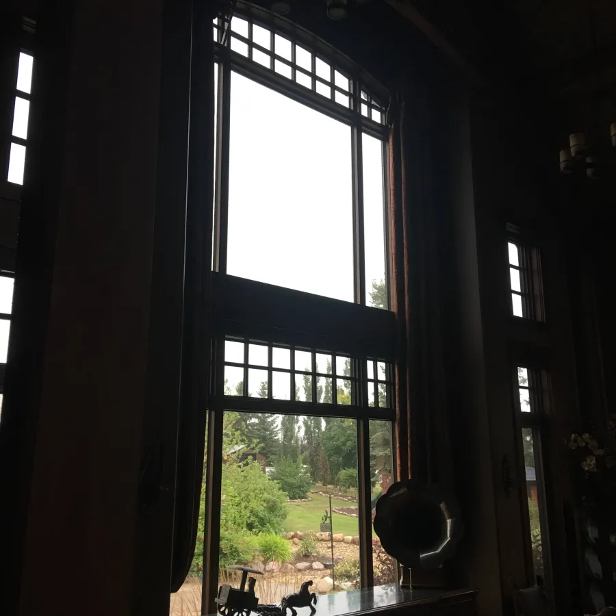 a large window with a view of a forest and a field