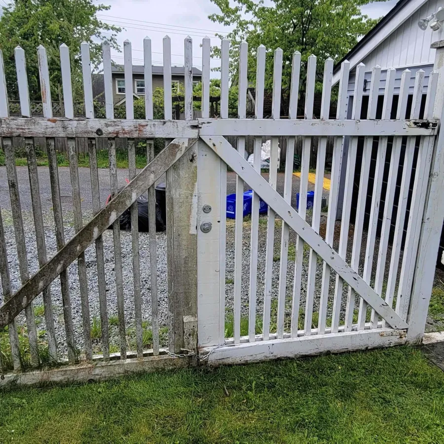 a white fence with a metal gate