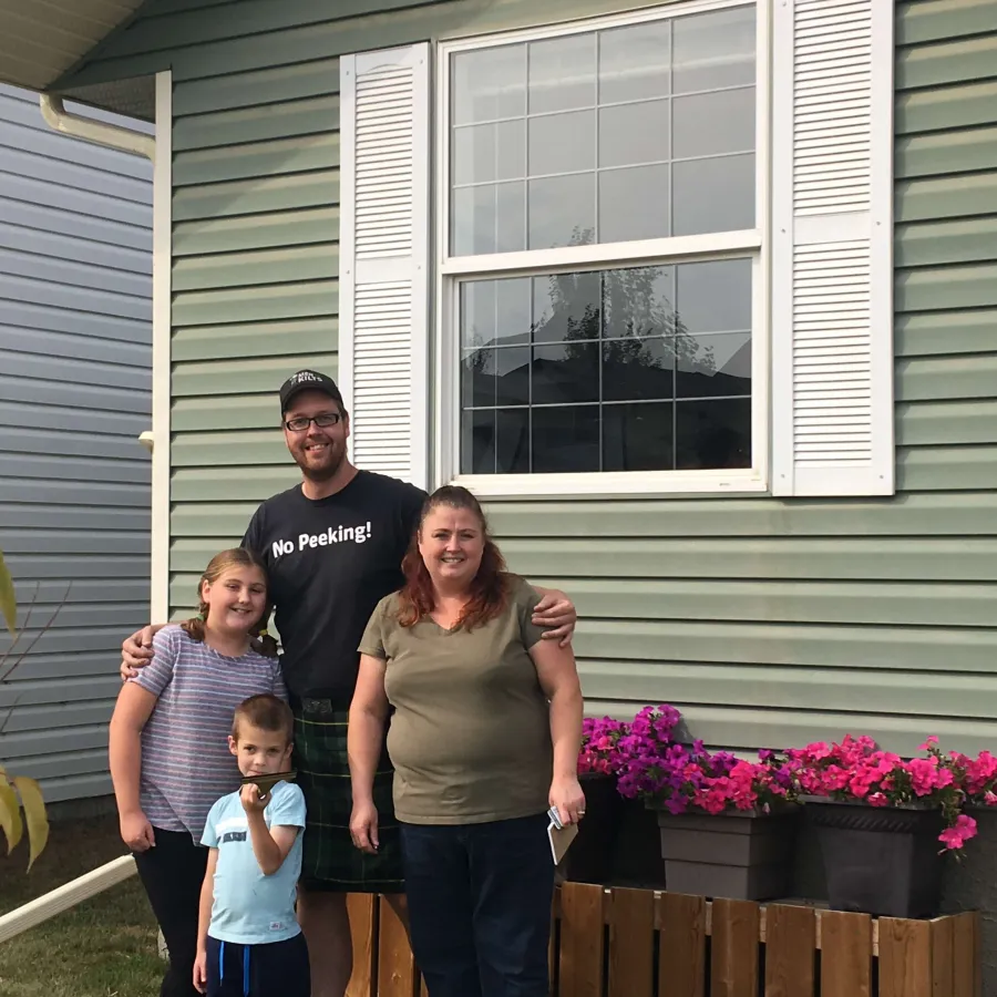 a family standing in front of a house