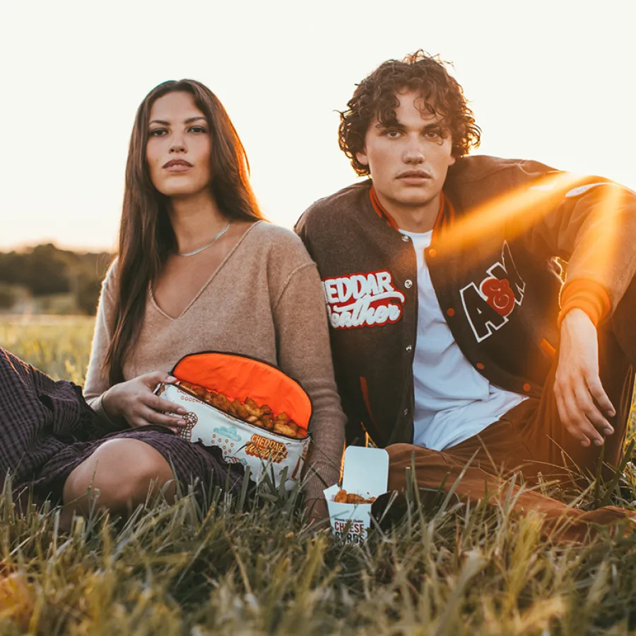 a man and woman sitting in a field with a frisbee