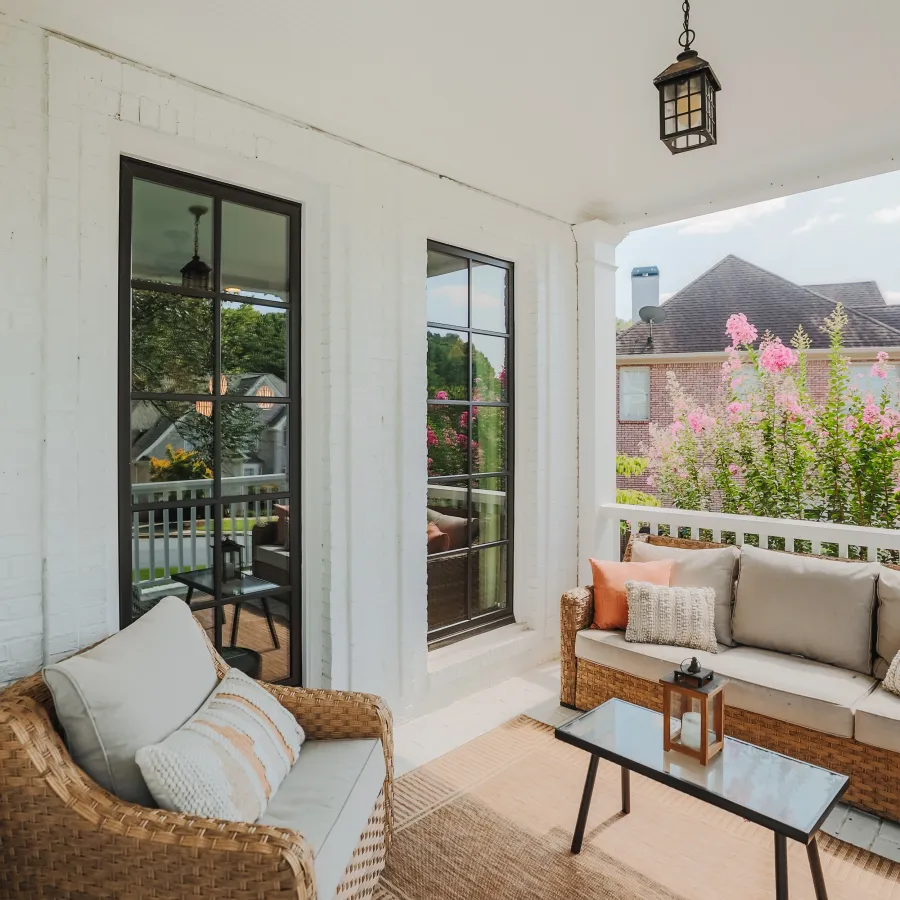 Cozy outdoor porch with black Infinity by Marvin casement windows and black grid pattern