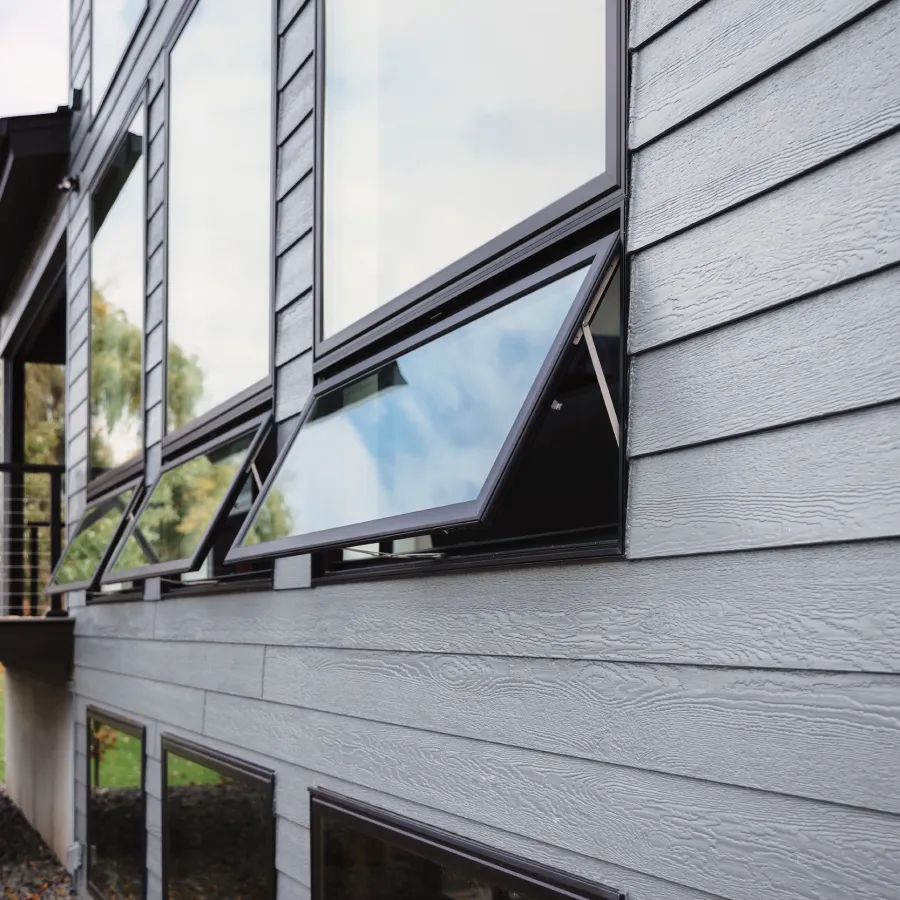 Gray house with open black awning windows installed by North Georgia Replacement Windows