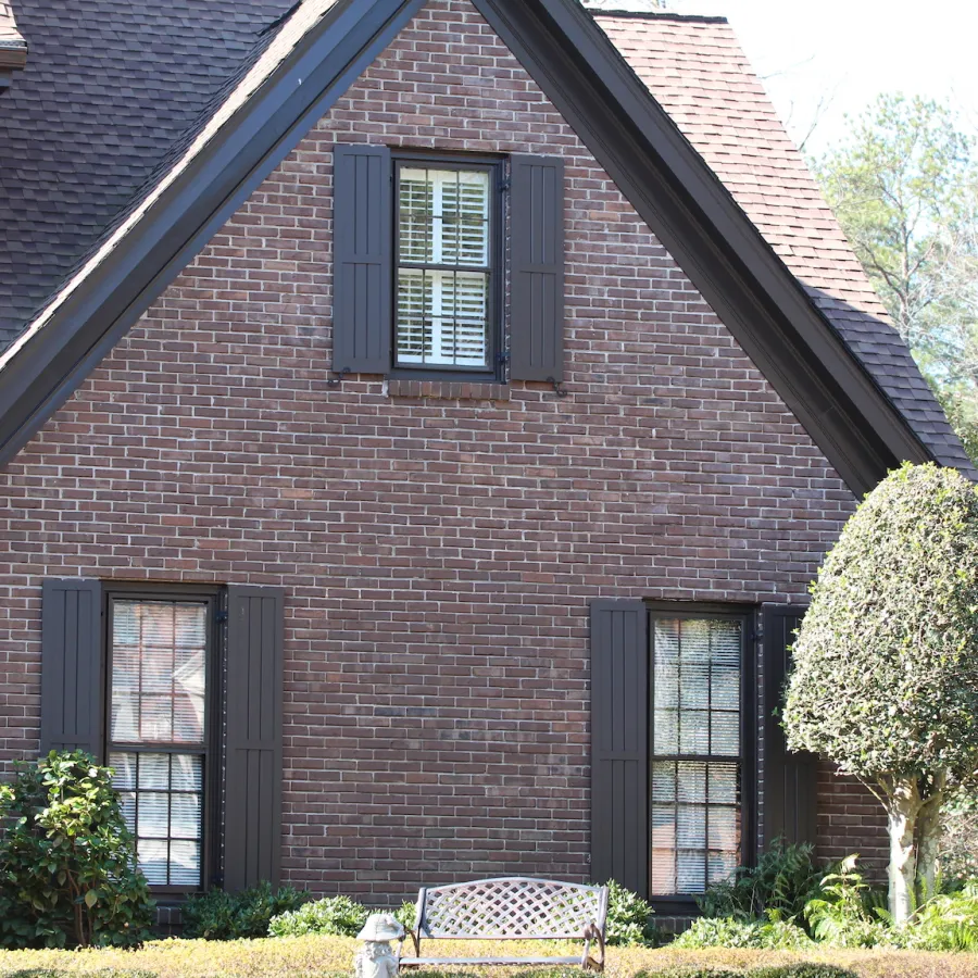 a brick house with black mission shutters