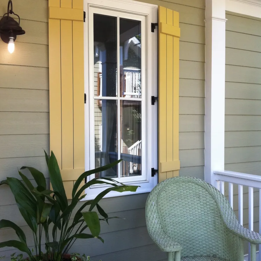 Yellow board and batten shutters on a green house
