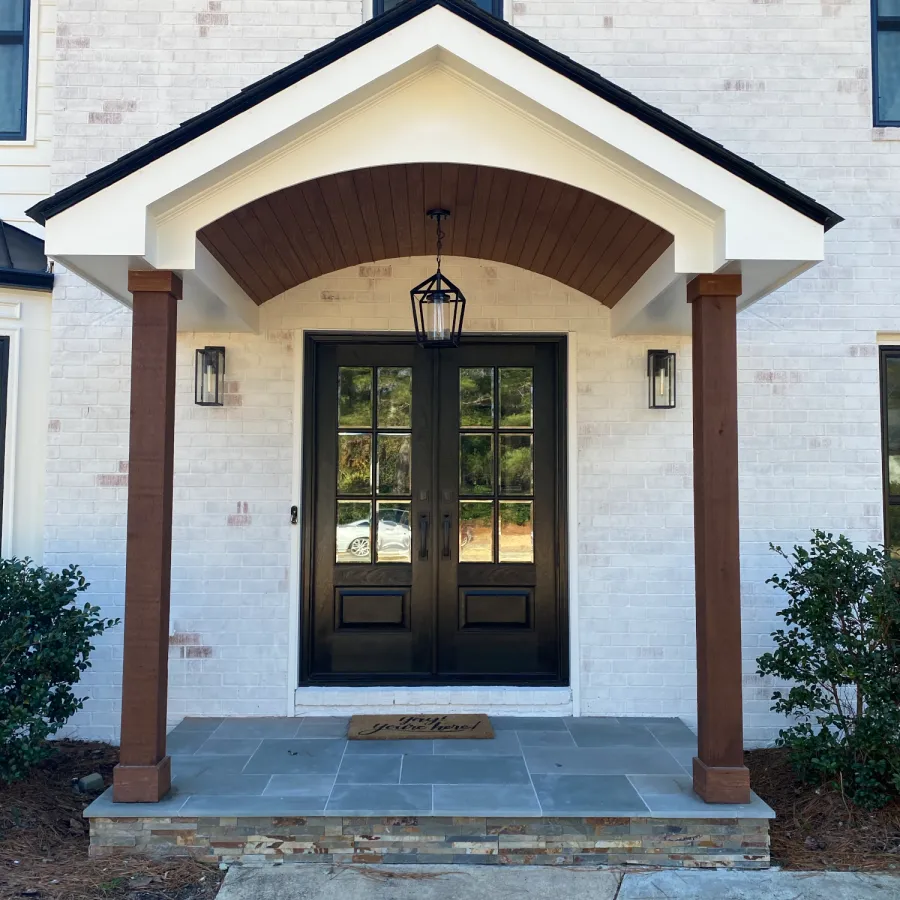White house with black double front door with glass 
