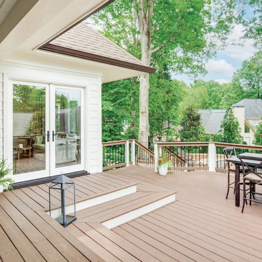 A deck with table and chairs as well as a white French door leading into the house