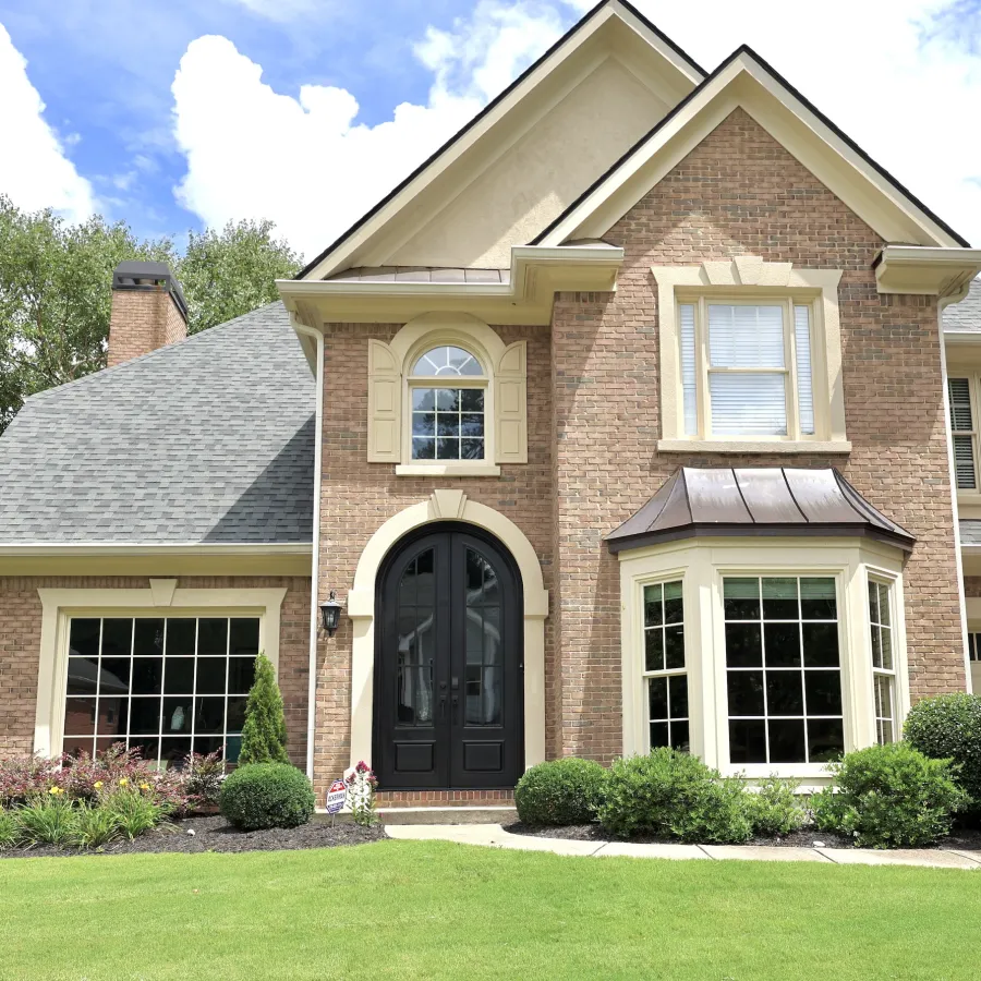 Brick house with double, arched, black iron front doors