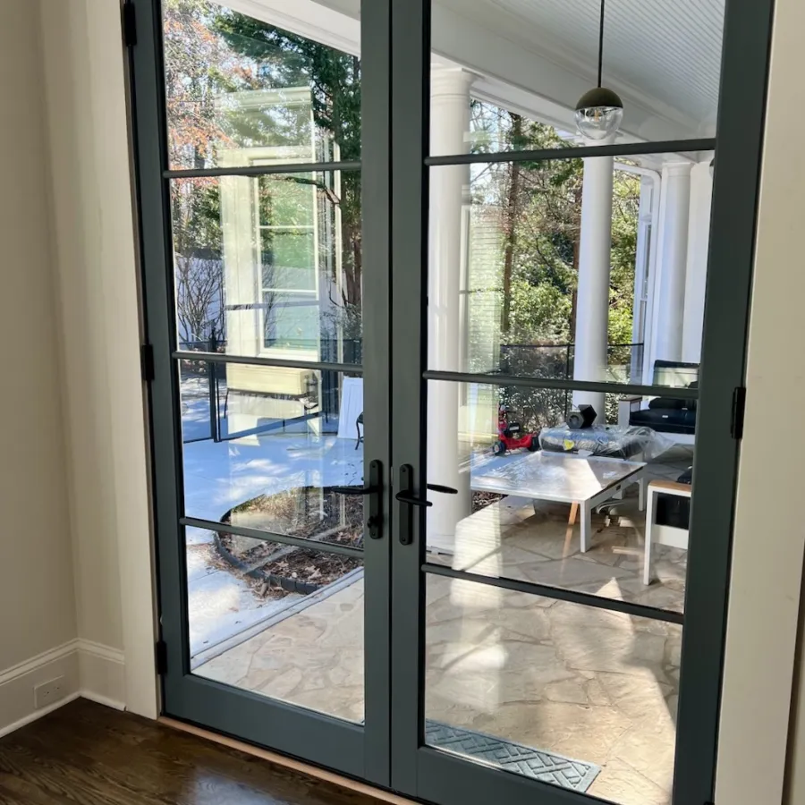Modern black fiberglass French doors leading onto patio
