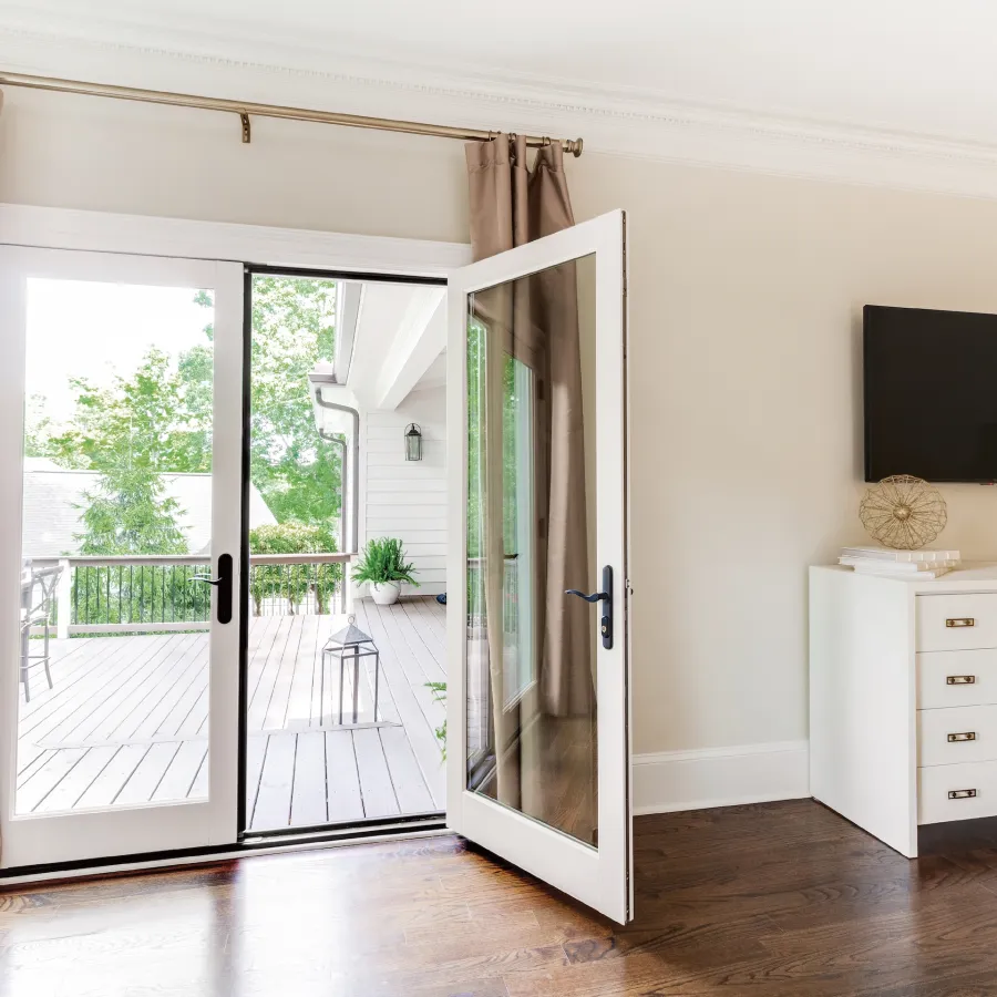 White fiberglass inswing French doors lead onto deck