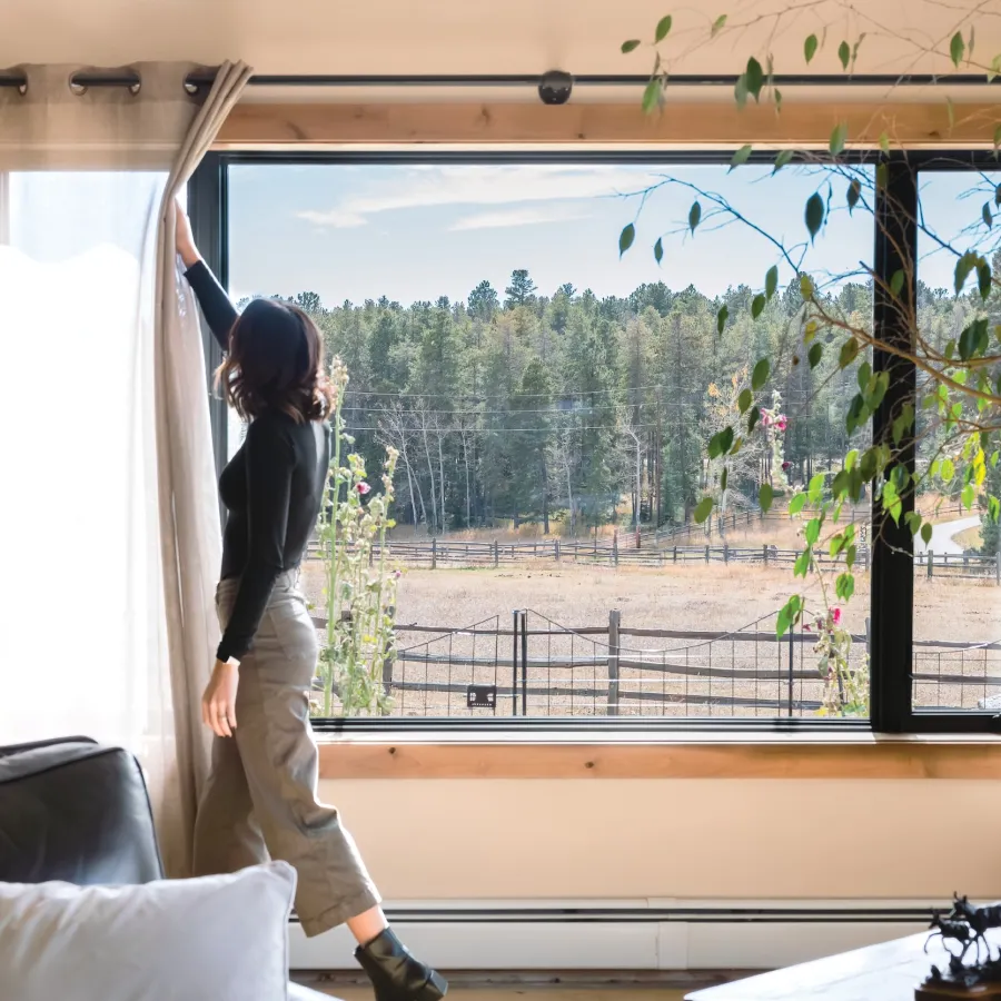 Opening curtains to enjoy the view through a large picture window