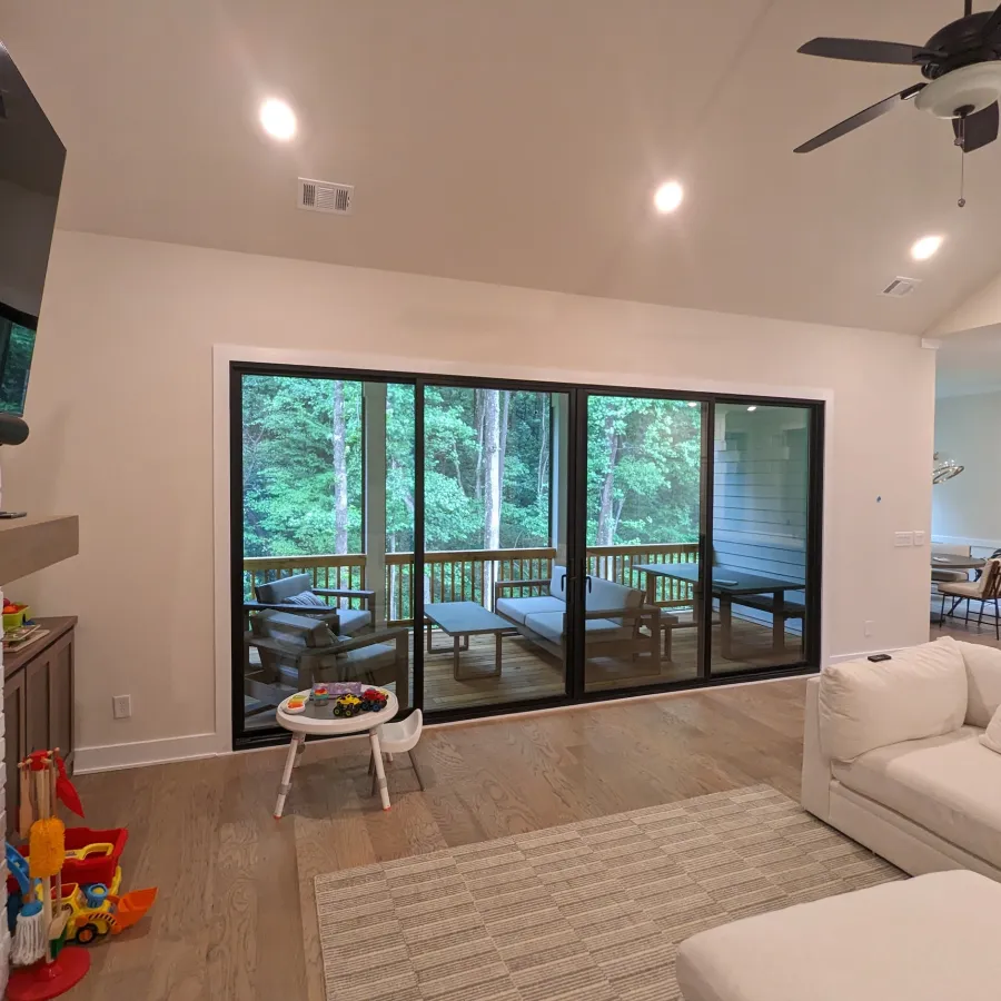 Black fiberglass sliding door connects living room to balcony