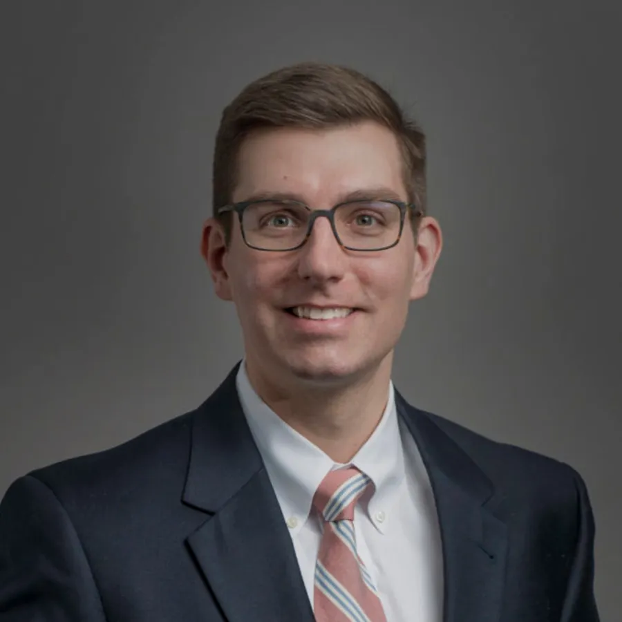 a man wearing glasses and a suit