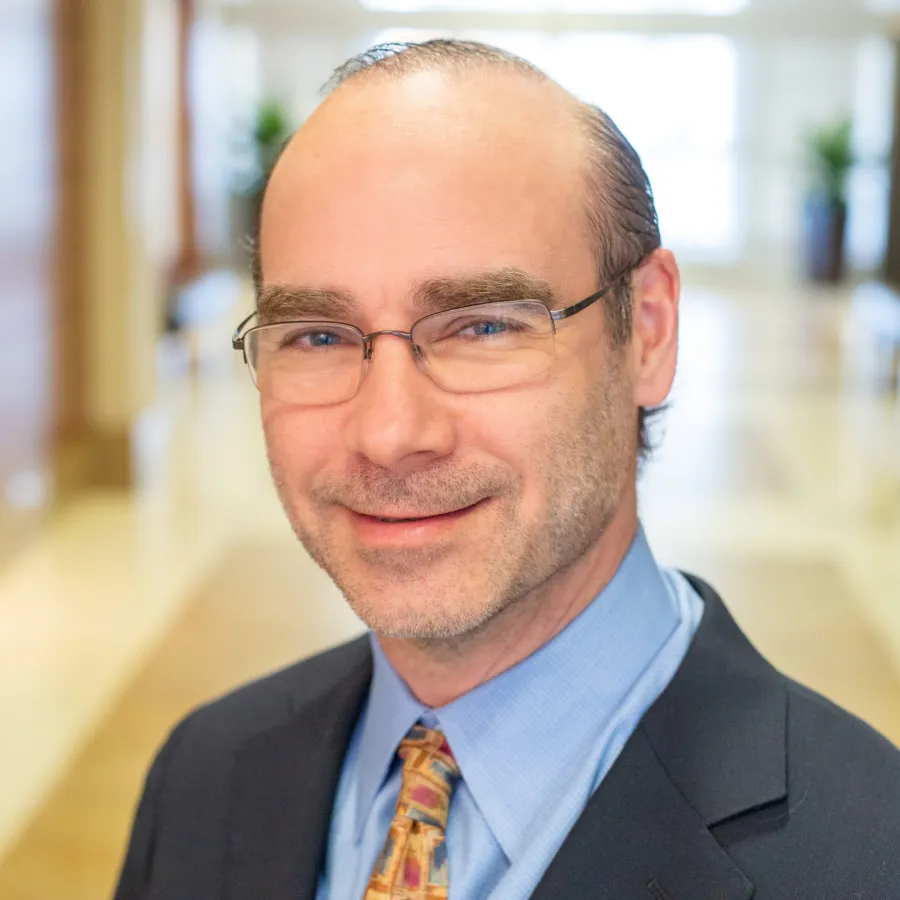 a man wearing glasses and a suit