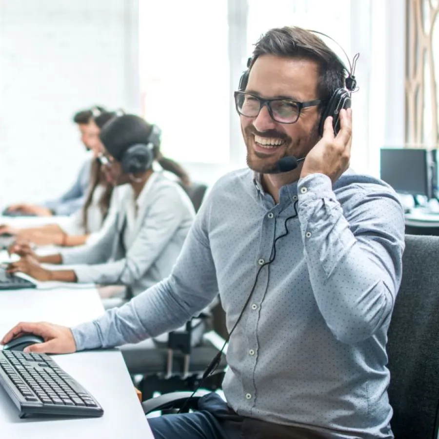 a person wearing headphones and sitting at a desk with a computer