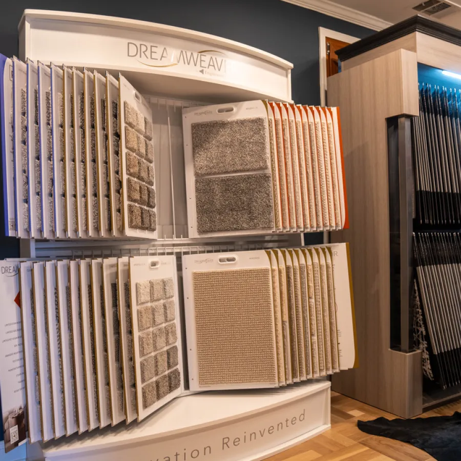 Carpet sample displays from Dreamweaver and Stanton showcasing various carpet textures and colors in a showroom.