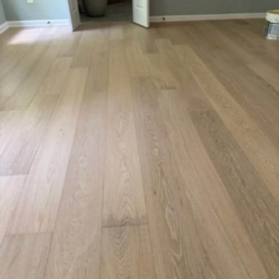 Light wood flooring in an empty room with gray walls and open double doors leading to another space