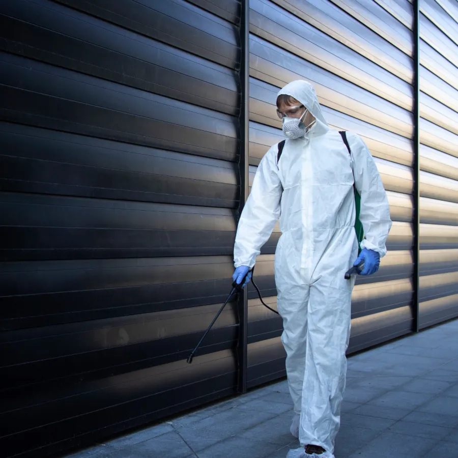 a person in a white lab coat and mask holding a cane